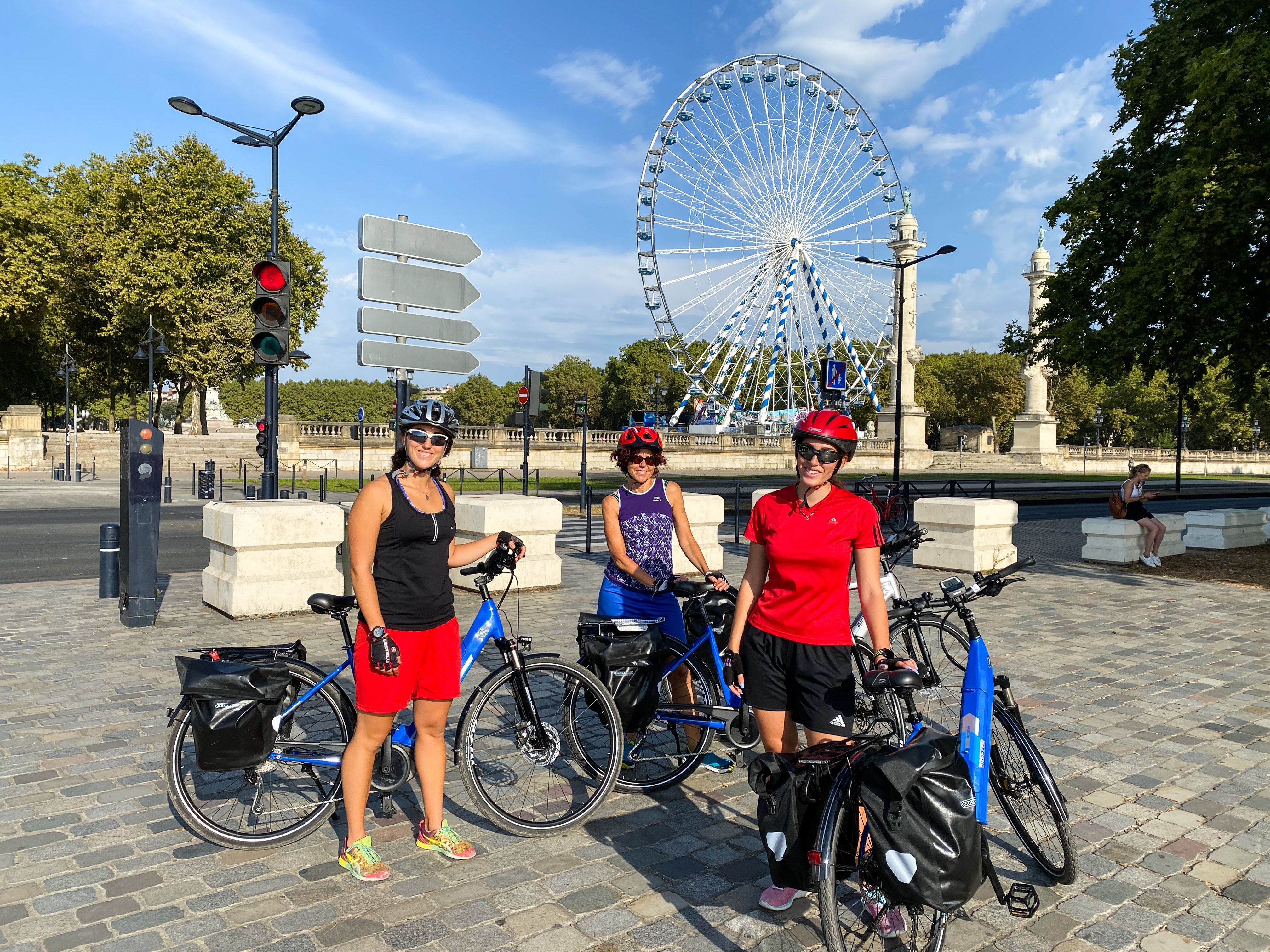 Gruppo di ciclisti con caschi rossi e biciclette blu, vacanze in bici con Girolibero